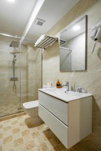 ein Badezimmer mit Waschbecken, Toilette und Spiegel in der Unterkunft Voyager in Mamaia Nord – Năvodari