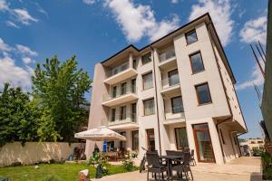 ein Gebäude mit Tischen und Stühlen davor in der Unterkunft Voyager in Mamaia Nord – Năvodari