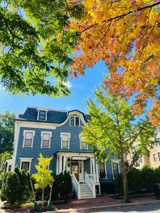 une maison bleue avec des arbres d'automne devant elle dans l'établissement Ginkgo House on Harvard, à Cambridge