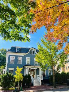 a blue house with autumn trees in front of it at Ginkgo House on Harvard in Cambridge