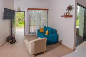 a living room with a blue couch and a chair at Villa Aurora with Jacuzzi in La Fortuna in Fortuna