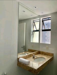 uma casa de banho com um lavatório e um espelho em Atlântico Vista Mar Deluxe em Fortaleza