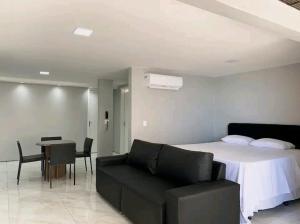 a bedroom with a bed and a couch and a table at Atlântico Vista Mar Deluxe in Fortaleza