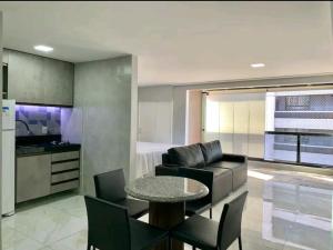 a living room with a table and a couch and a kitchen at Atlântico Vista Mar Deluxe in Fortaleza