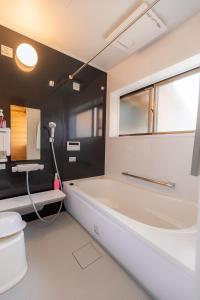 ein Badezimmer mit einer Badewanne, einem WC und einem Waschbecken in der Unterkunft Goto I-House in Goto