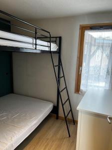 a bunk bed in a room with a ladder next to a window at Appartement BELLE PLAGNE et PARKING in Belle Plagne