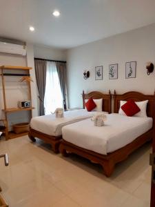 a bedroom with two beds and a window at Villa Thai Orchid (adult only) in Chiang Mai
