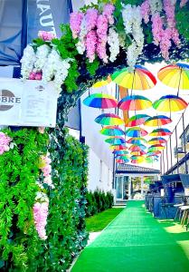 een loopbrug met parasols en bloemen op een gebouw bij Dobre Smaki Apartaments Chill and Food in Sarbinowo