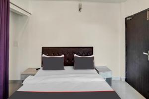 um quarto com uma cama grande e uma cabeceira em madeira em Collection O Babil Palace em Gurgaon