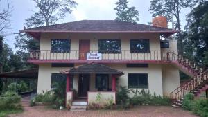 a house with a balcony and a sign on it at Magod Homestay in Idgundi