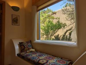 uma janela num quarto com um sofá em frente em Adorable Adobe Taos - excellent location between ski valley and town! em El Prado