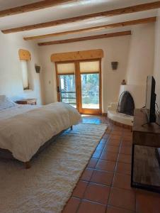 um quarto com uma cama grande e uma lareira em Adorable Adobe Taos - excellent location between ski valley and town! em El Prado