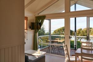 a dining room with a view of a balcony at Surf Beach Narooma Holiday Park in Narooma