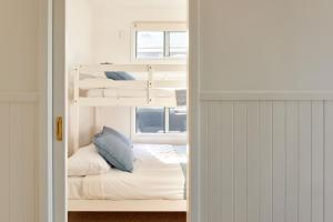 a room with two bunk beds and a window at Surf Beach Narooma Holiday Park in Narooma