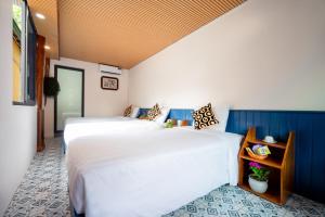 two beds in a room with blue and white at Catba Papillon Garden Bungalows & Resort in Cat Ba