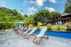 a row of lounge chairs on a patio at Catba Papillon Garden Bungalows & Resort in Cat Ba