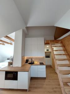 a kitchen with white cabinets and a staircase at Apartamentai Emilija in Nida