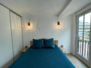 a bedroom with a blue bed and a large window at Appartement Central, Tout Équipé et Confortable pour 4 Personnes à Arcachon - FR-1-474-244 in Arcachon