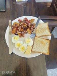 een bord eten met eieren en toast op een tafel bij Gold star guest house and cafe in Tosh