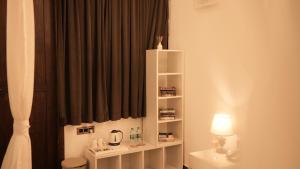 a bathroom with a black curtain and a white shelf at Prive by Whiteflower in Vagator