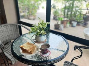 a table with a sandwich and a cup of coffee at V Tharm Hotel in Udon Thani