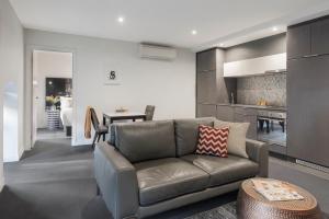 a living room with a couch and a kitchen at Imagine Southbank in Melbourne