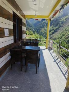 a balcony of a house with a table and chairs at Gold star guest house and cafe in Tosh
