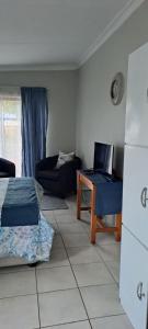 un soggiorno con divano e scrivania con computer portatile di The Cottage Unit a Bloemfontein Altre 6 foto