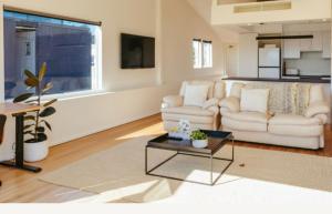 a living room with a couch and a table at Spectacular views over Albert Park in Melbourne