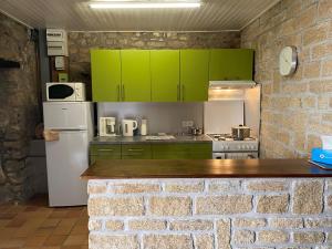 uma cozinha com armários verdes e um frigorífico branco em Maison Étel, 3 pièces, 4 personnes - FR-1-397-6 em Étel