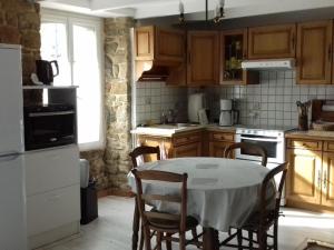 uma cozinha com uma mesa e cadeiras numa cozinha em Maison Belz, 3 pièces, 4 personnes - FR-1-397-19 em Belz