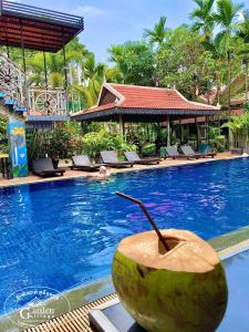 a coconut sitting on the edge of a swimming pool at Garden Village Guesthouse & Pool Bar in Siem Reap