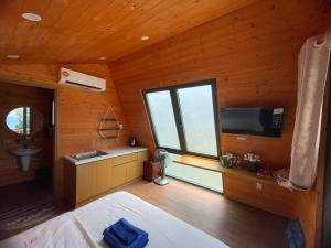 a bedroom with a large window and a sink and a television at Tân Thành Resort in Ke Ga