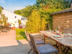 a wooden table and chairs on a patio at Maison Charmante à Ploemeur - Proche Plages et Campagne - 7 Couchages avec Jardin et Wifi - FR-1-349-105 in Ploemeur