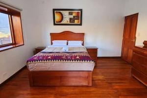 um quarto com uma cama de madeira num quarto com uma janela em El Rey Lobo Casa de Campo Valle Sagrado em Urubamba