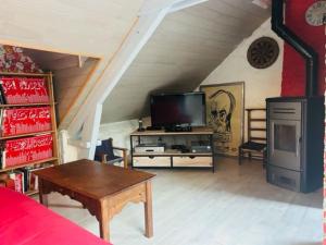 uma sala de estar com uma televisão e uma mesa em Gite de charme en Bretagne 