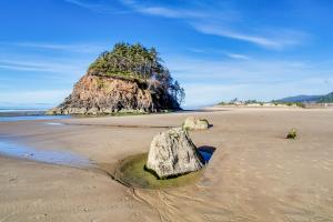 a rock in the sand on a beach at Proposal Rock Charmer in Neskowin