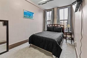 a bedroom with a bed and a large window at Perfect Blend of Convenience & Comfort Syracuse NY in Syracuse