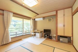 a living room with a desk and a large window at リバーサイドひの in Hino