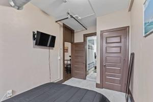 a bedroom with a bed and a tv and a door at Perfect Blend of Convenience & Comfort Syracuse NY in Syracuse