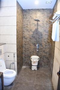 a bathroom with a toilet and a shower at Hotel Royal Comfort Inn in Pinjaur