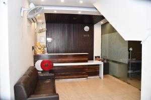Hotel Royal Comfort Inn في Pinjaur: غرفة معيشة مع أريكة جلدية وطاولة