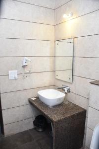 bagno con lavandino bianco e specchio di Hotel Royal Comfort Inn a Pinjaur