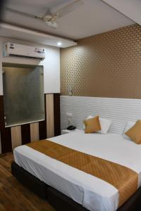 Hotel Royal Comfort Inn في Pinjaur: غرفة نوم بسرير كبير وشاشة عرض