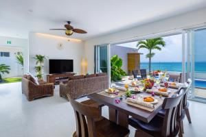 a dining room with a table with food and the ocean at Coldio Marina Kin B032 in Kin