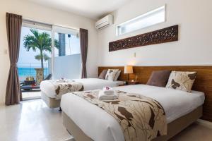 two beds in a bedroom with a view of the ocean at Coldio Marina Kin in Kin +52 photos
