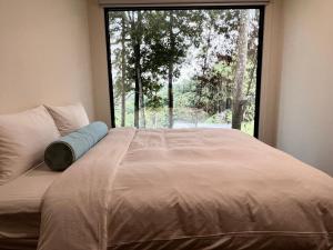 a bed in a room with a large window at 方圓行止 Funyuan Village in Puli