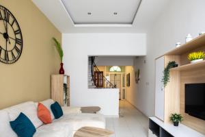 a living room with a white couch and a clock at Entire Luxury Sliema Townhouse Steps from Beach in Sliema
