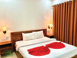 una camera da letto con un letto con due fiori rossi sopra di Garden Village Guesthouse & Pool Bar a Siem Reap