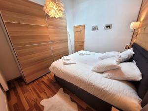 1 dormitorio con 1 cama con sábanas y almohadas blancas en Appartement Les Gets, 2 pièces, 4 personnes - FR-1-598-145, en Les Gets